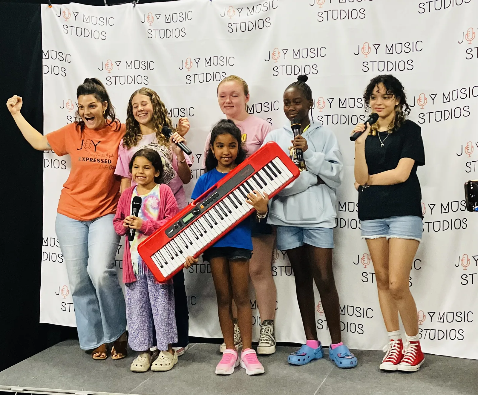Students celebrating on stage after performing at a studio showcase
