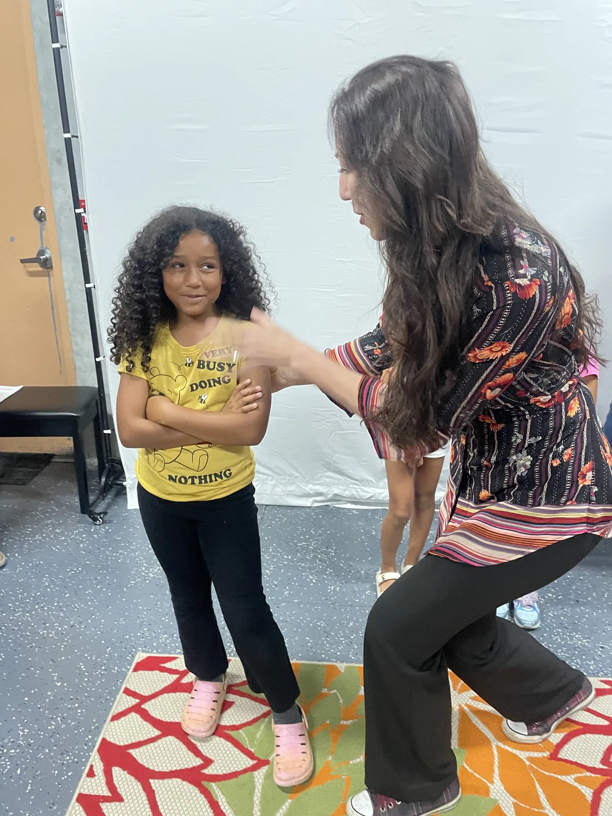 Instructor coaching a young student through an acting exercise