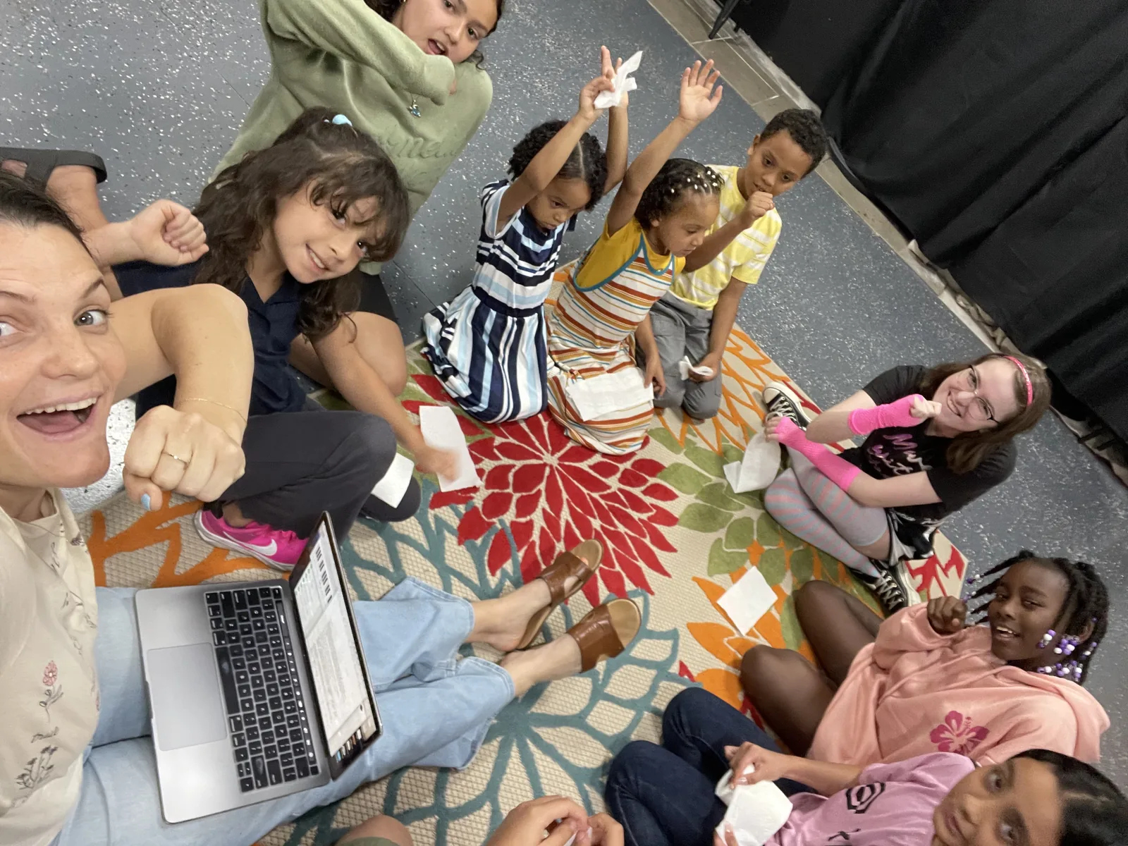 Kids gathered in a circle on the studio rug during a group music class
