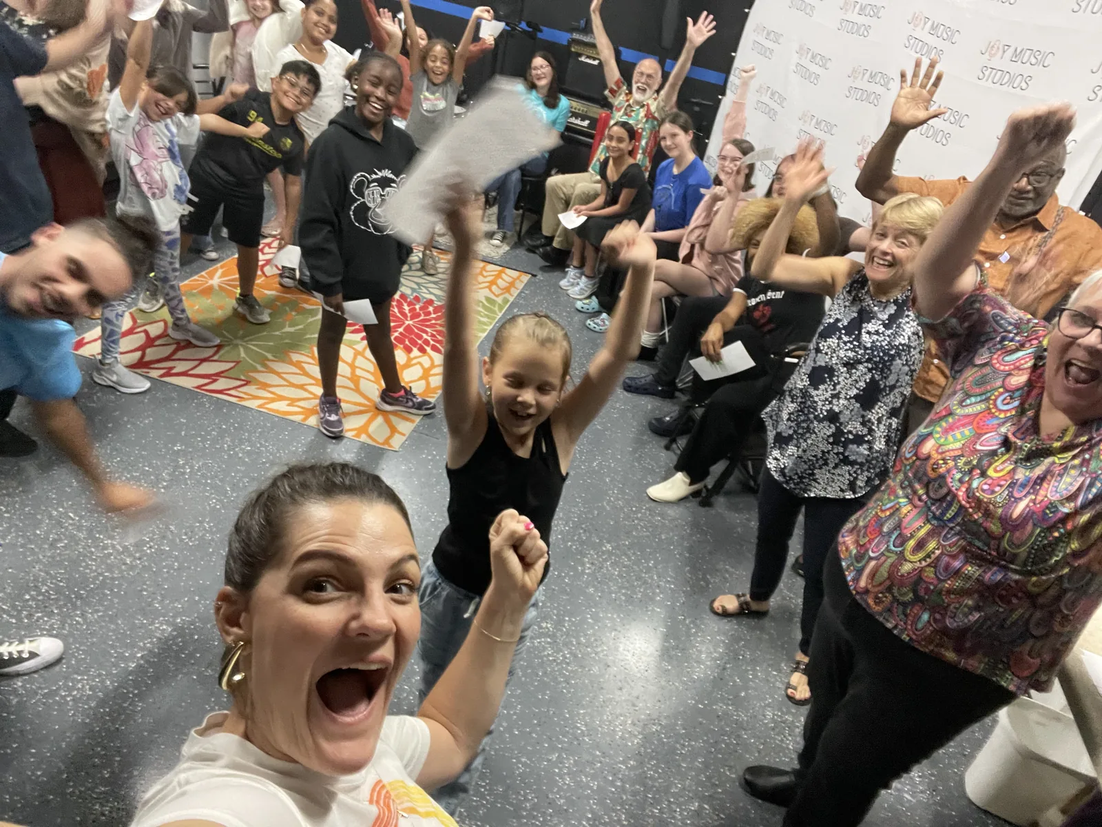 Cast members cheering together after a Joy Music Studios production
