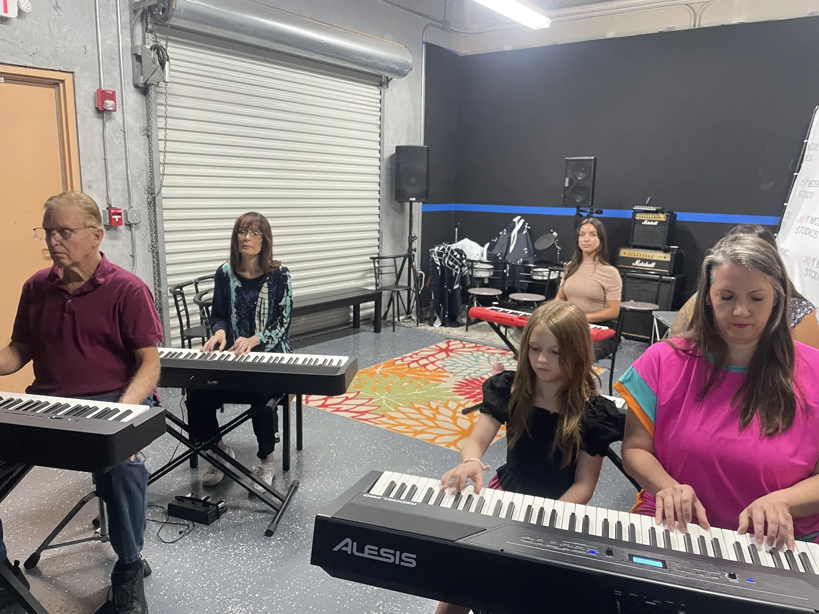 Adult students playing keyboards during a piano class
