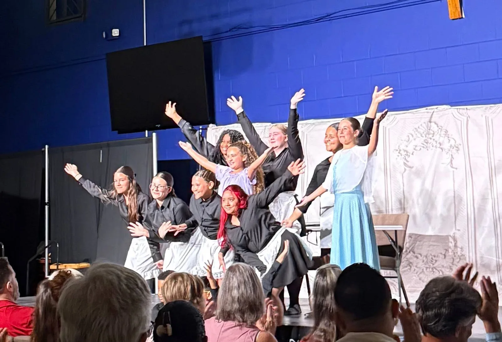 Young performers raising their hands during a studio musical production